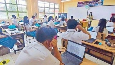 Students use laptops as Para&Atilde;&plusmn;aque National High School turns to &acirc;hylearn learning,&acirc; a type of hybrid learning system, during in-person classes on Feb. 14, 2022.